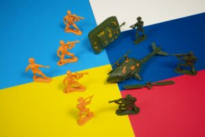 Due serie di soldatini giocattolo, una gialla e una verde, schierate una contro l'altra su uno sfondo a blocchi colorati