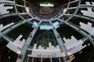 immagine con punto di vista dal basso verso l'alto di architettura di un edificio di google. Vista dall'interno, effetto circolare. Colori freddi.