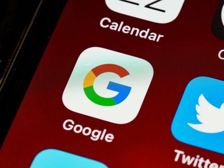 Immagine dell'icona dell'app di Google sulla schermata di un cellulare con sfondo rosso vino.
