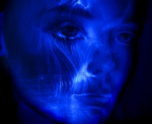 Foto viso visto a 3/4, blu con delle luci che potrebbero sembrare flussi di energia elettrica; a rappresentare un volto dell'IA.