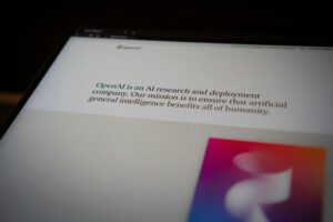 Immagine schermata tablet, pagina di OpenAI in cui c'è scritta la descrizione, tra cui che uno dei suoi obiettivi è l'essere a servizio dell'umanità.