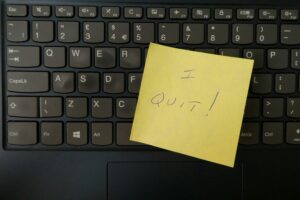 Immagine di un post-it su una tastiera nera di un pc, con su scritto "I quit"