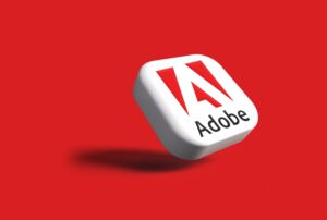 logo Adobe in 3D su sfondo rosso acceso.