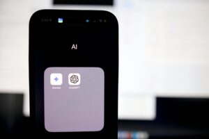 primo piano su iphone con cartella "IA" che contiene Gemini e ChatGPT