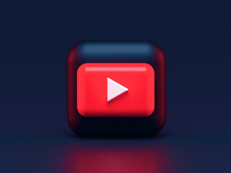 Logo di YouTube in un cubo 3D con gli spigoli arrotondati in un ambiente nero.
